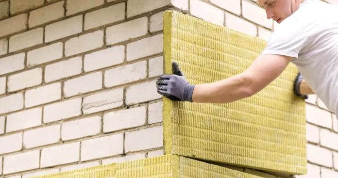 Pensionar verificand documentele pentru izolarea termica a casei cu un auditor energetic