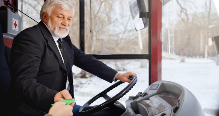 Șofer de TIR odihnindu-se în cabina camionului în timp ce își analizează un fluturaș de salariu și documentele de delegare