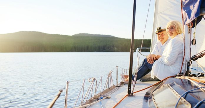 Membru al echipajului privind marea de pe puntea unui vas de croazieră imens aflat în apele internaționale