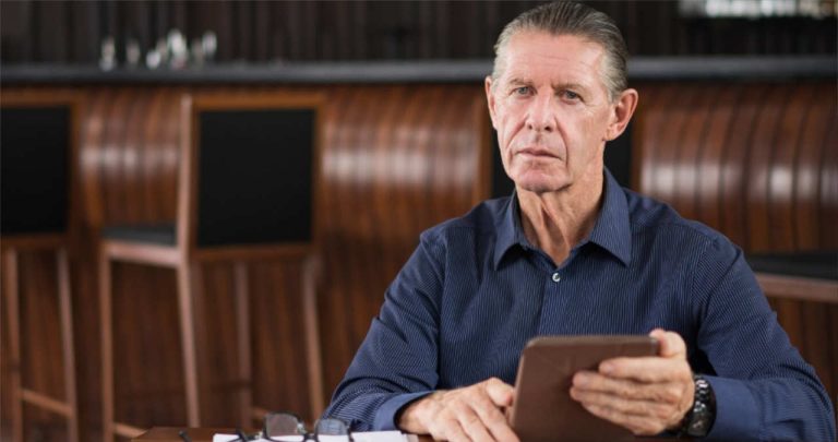 Un avocat pensionar semnand actele de cumulare a pensiei la biroul sau