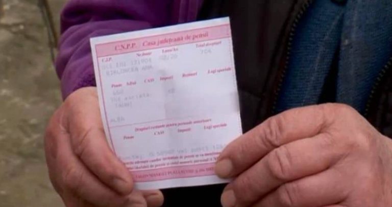 Un pensionar analizând îngrijorat o decizie de pensionare greșită alături de vechiul său carnet de muncă la birou