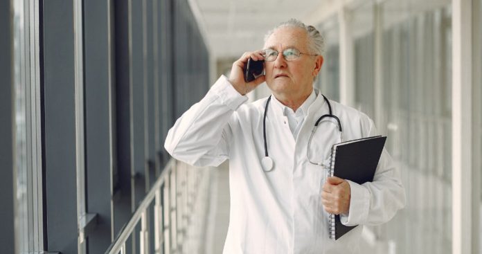 Medic semnând dosarul de pensionare și documentele oficiale pentru prelungirea activității medicale