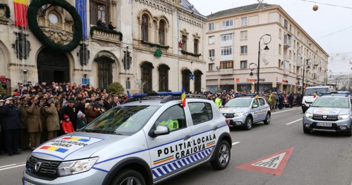 Un agent de poliție locală într-o mașină de patrulare discutând cu un agent din Poliția Națională a României pe stradă