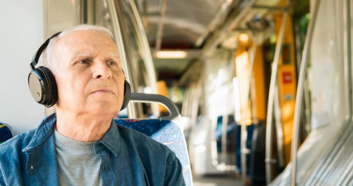 Un mecanic de locomotivă în uniformă CFR coborând din tren cu dosarul de pensionare pregătit în mână