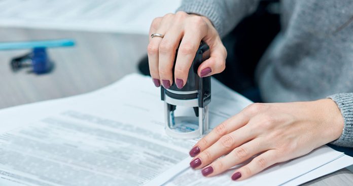 Un pașaport românesc așezat pe un birou lângă o procură specială notarială apostilată