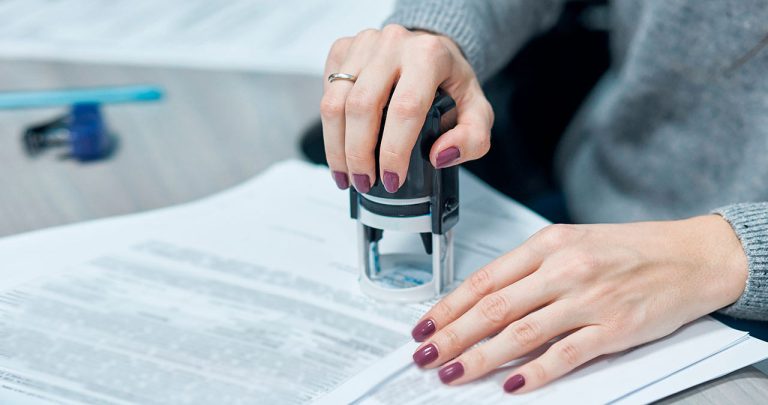 Un pașaport românesc așezat pe un birou lângă o procură specială notarială apostilată