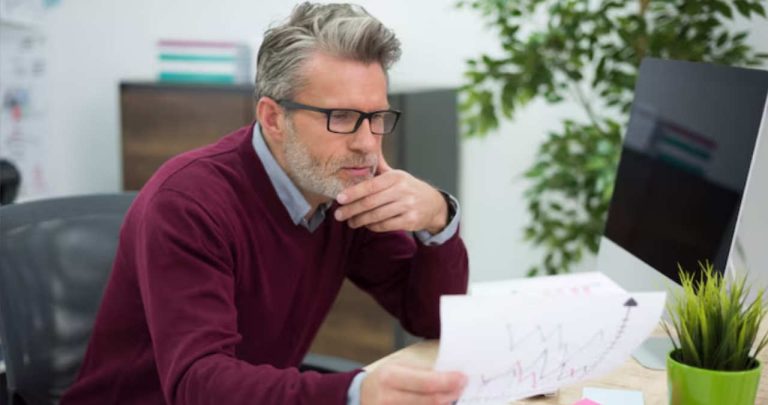 Pensionar antreprenor lucrand la laptop pentru un proiect cu fonduri europene