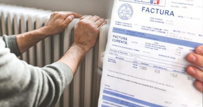 Pensionar ținând în mână un card de energie și o factură de curent electric pregătit să facă plata