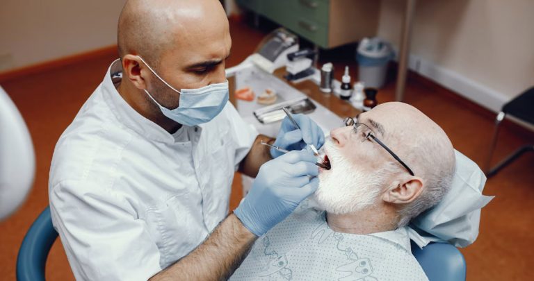 Medic stomatolog lucrând într-un cabinet pentru servicii stomatologice decontate de CAS